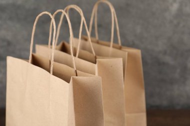 Bulanık arkaplanda Kraft kağıt torbaları, yakın plan.