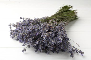 Beyaz ahşap masada lavanta çiçeği demeti, yakın plan.