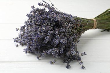 Beyaz ahşap masada lavanta çiçeği demeti, yakın plan.