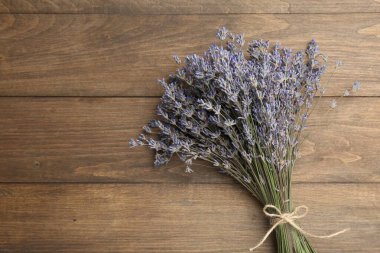 Ahşap masanın üzerinde bir demet aromatik lavanta çiçeği, üst manzara. Metin için boşluk