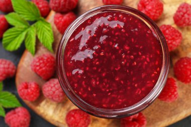 Cam kavanozda tatlı ahududu reçeli ve masada böğürtlen.