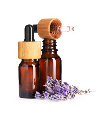 Lavanta yağı, çiçekli ve damlatıcılı şişelerde beyaza izole edilmiş.