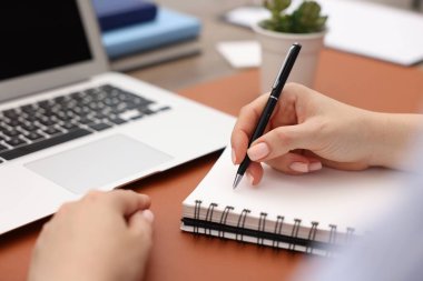 Masada dizüstü bilgisayarda yazan metin yazarı, yakın plan.