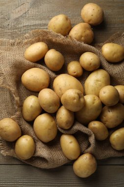 Tahta masada bir sürü çiğ patates ve çuval bezi vardı.