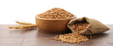 Tahta masada beyaz arka planda buğday taneleri, çuval ve çiviler