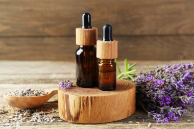 Ahşap masada taze ve kuru çiçekli lavanta yağı, yakın plan.