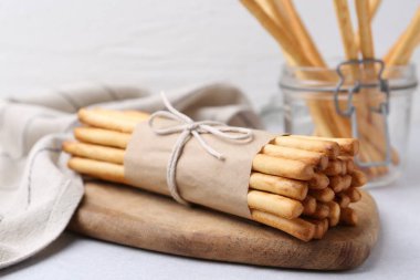 Lezzetli Grissini açık gri masaya yapışıyor, yakın plan.