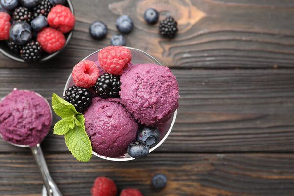 Delicious sorbet with fresh berries and mint on wooden table, flat lay. Space for text