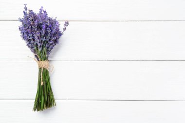 Beyaz ahşap masa üzerinde bir demet güzel lavanta çiçeği, üst manzara. Metin için boşluk