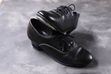 Gri yüzeyde step dansı için bir çift ayakkabı, yakın plan.