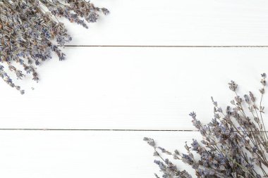 Beyaz ahşap masa üzerinde kokulu lavanta çiçekleri, düz yatıyordu. Metin için boşluk