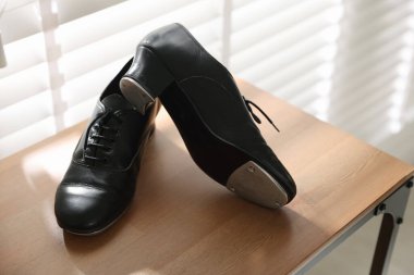 Kapalı alanda, ahşap rafta step dansı için bir çift ayakkabı.