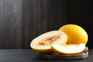 Kesilmiş ve olgun karpuzlar siyah ahşap masada, yakın plan. Metin için boşluk