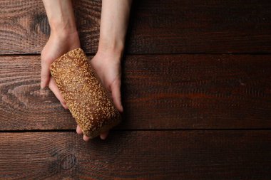 Ahşap masada bir somun taze ekmeği olan bir kadın. Metin için boşluk