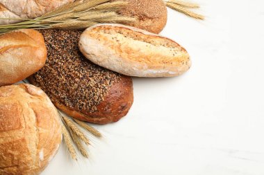 Beyaz mermer masada farklı ekmek ve buğday çivileri var. Metin için boşluk