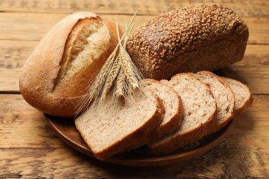 Tahta masada farklı ekmek ve buğday çivileri, yakın plan.