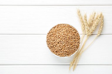 Kasede buğday taneleri, beyaz ahşap masada çiviler düz yerde. Metin için boşluk