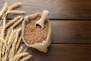 Çuval bezi torbasında buğday taneleri, tahta masada kepçeler ve çiviler. Metin için boşluk