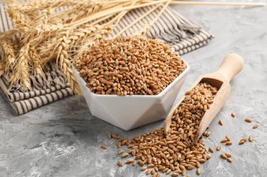 Kasede buğday taneleri, gri masada kepçeler ve çiviler, yakın plan