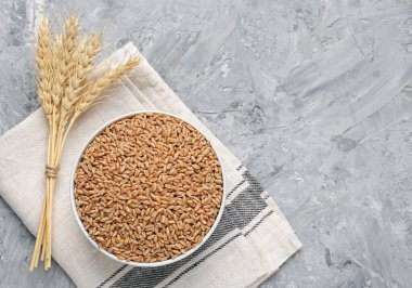 Kasede buğday taneleri ve gri masada sivri uçlu çiviler. Metin için boşluk