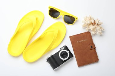 Yaz tatili zamanı. Kamera, pasaport ve plaj aksesuarları beyaz arka planda, düz yerde