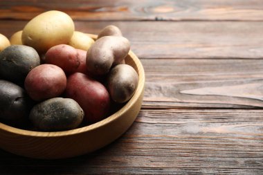 Tahta masadaki kasede farklı tipte patatesler, yakın plan. Metin için boşluk