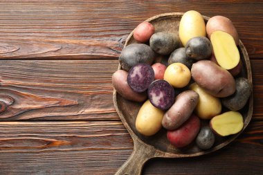 Tahta masadaki farklı patates türleri, üst manzara. Metin için boşluk