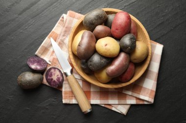 Kasede farklı patates çeşitleri ve siyah masada bıçak, düz yatıyordu.