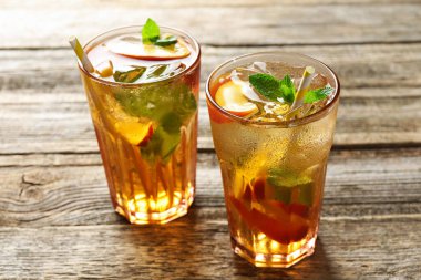 Buzlu şeftali çayını ahşap masada bardaklarda tazeliyorum. Yakın plan.