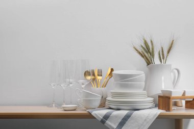 Temiz beyaz bulaşık takımı, bardaklar, çatal bıçak takımı ve çiviler.