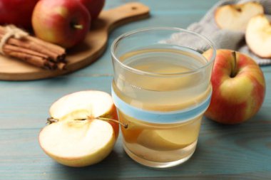 Lezzetli cam karışımı, taze elma ve tarçın açık mavi ahşap masa, yakın plan.