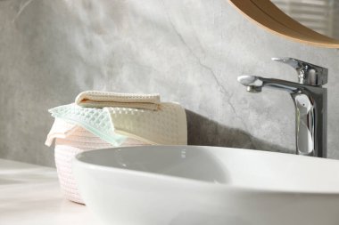 Banyoda lavabonun yanında temiz waffle havluları, yakın çekim.