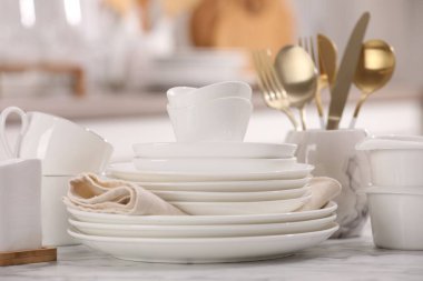 Farklı beyaz bulaşık takımları, bardaklar ve çatal bıçaklar, kapalı masa, yakın çekim.