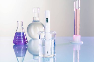 Beyaz masa üzerinde su ve cam beher ile beher içinde nitrat testi, yakın çekim