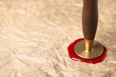 Buruşmuş kağıdı balmumu puluyla mühürlemek, yakın plan. Metin için boşluk