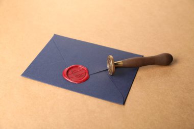 Güzel balmumu mühür, kırmızı mühürlü zarf ve bej arka planda sicim, yakın plan.