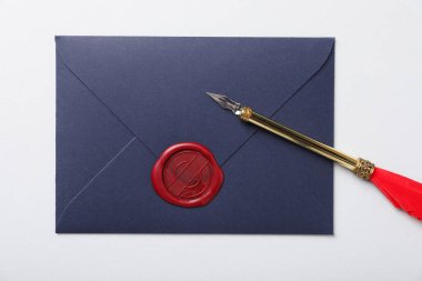 Beyaz zemin üzerinde balmumu mühür ve dolmakalem ile zarf, üst görünüm