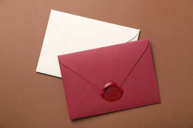 Kahverengi zemin üzerinde balmumu mühürü olan zarflar, üst görünüm