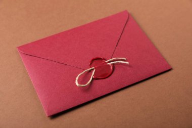 Kahverengi zemin üzerinde balmumu mühür ve sicim olan zarf, yakın plan