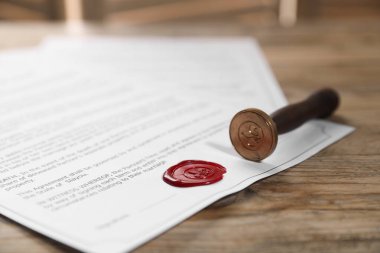 Balmumu mühür ve damgalı belgeler ahşap masaya, yakın plan.