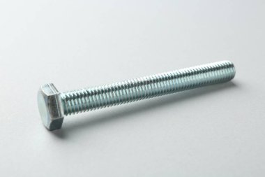 Beyaz arka planda metal bir cıvata, yakın plan. Donanım aracı