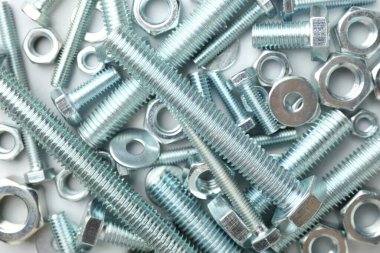 Beyaz arka planda metal cıvatalar ve fındıklar, düz yatış