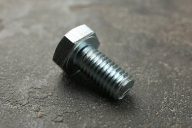 Gri masada bir metal cıvata, yakın plan.