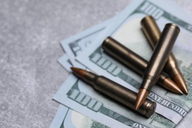 Mermiler ve paralar gri masaya, yakın plan. Metin için boşluk