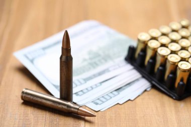 Kurşunlar ve dolarlar ahşap masada, yakın plan.