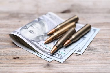Kurşunlar ve dolarlar ahşap masada, yakın plan.