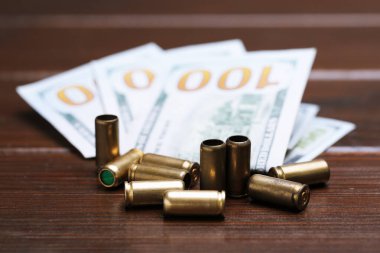 Kurşunlar ve dolarlar ahşap masada, yakın plan.