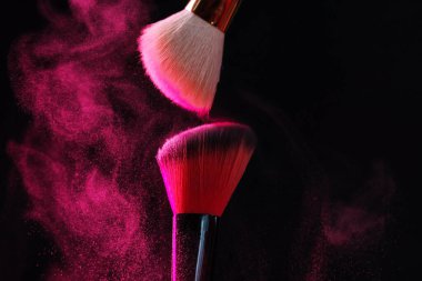 Siyah arka planda pembe göz farlı makyaj fırçaları, yakın plan