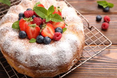 Tahta masada pudra şekeri ve böğürtlenli Lezzetli kek, yakın plan.