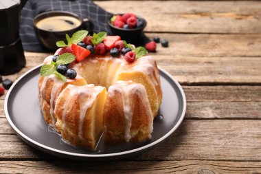 Lezzetli kek parçaları, böğürtlenli, jöleli ve naneli ahşap masa, yakın plan.